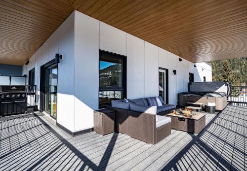 a living room with a couch and a table on a deck at The Big Deck by Revelstoke Vacations in Revelstoke