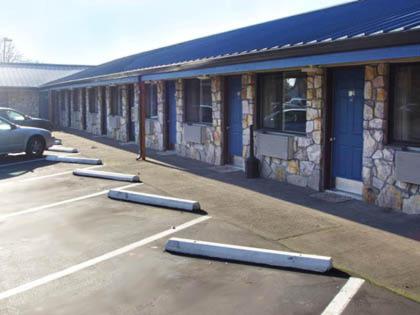 een parkeerplaats met afzettingen voor een gebouw bij Towne and Country Motel in Newberg