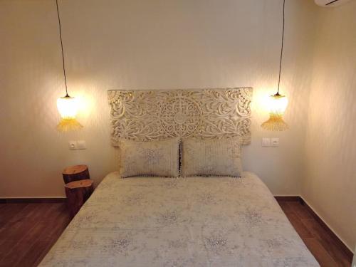 a bedroom with a large bed with two lights at 'ΟΜΟΡΦΟΣ ΧΩΡΟΣ ΣΤΙΣ ΑΛΥΚΕΣ ΒΟΛΟΥ in Volos