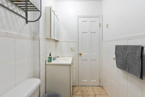 Lovely 3 bedroom apartment in NYC 2 في نيويورك: حمام أبيض مع حوض ومرحاض