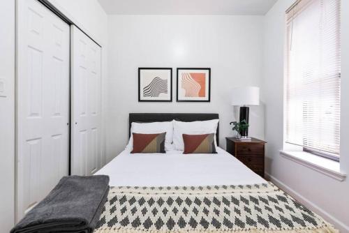 Lovely 3 bedroom apartment in NYC 2 في نيويورك: غرفة نوم بسرير وبطانية بيضاء وسوداء