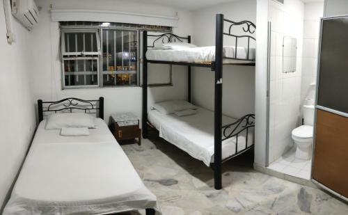 a room with two bunk beds and a toilet at Hostal El Mohan in Neiva