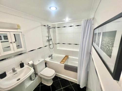 een badkamer met een toilet, een bad en een wastafel bij 2 Bed Serviced Apartment with Balcony, Free Parking, Wifi & Netflix in Basingstoke in Basingstoke