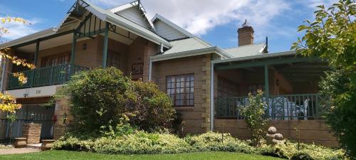 a large house with a porch and a balcony at Clarens Mount Rose self-catering holiday house in Clarens