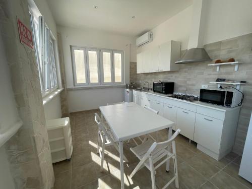 a kitchen with a table and chairs and a microwave at Villa Tonia in San Pietro in Bevagna