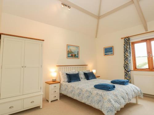 a bedroom with a bed with blue pillows on it at Kestrel, 19 Dartmouth Green in Totnes