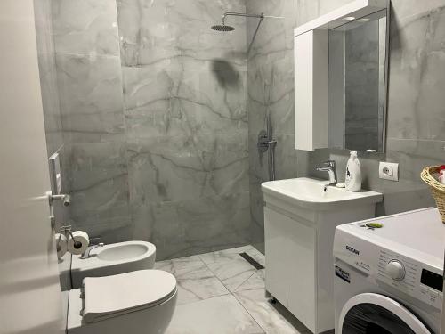 e bagno con servizi igienici, lavandino e doccia. di Comfy Nest Apartment- free parking a Tirana