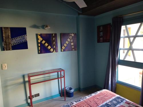 a bedroom with a bed and a window at Cuartos en el segundo piso de casa de artista en Flores in Buenos Aires