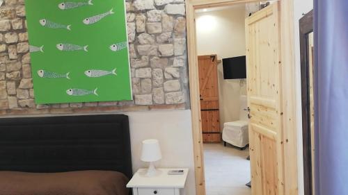 a bedroom with a bed and a green poster of fishes at Villa Antonella in Palermo