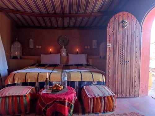 - une chambre avec un lit et deux ottomanes dans l'établissement Rêves de désert, à M'Hamid El Ghizlane