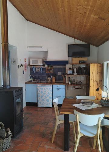 a kitchen with a table and chairs and a stove at Monte da Choça in São Teotónio