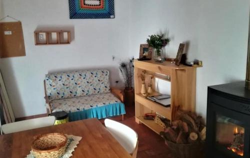 a living room with a table and a chair and a fireplace at Monte da Choça in São Teotónio