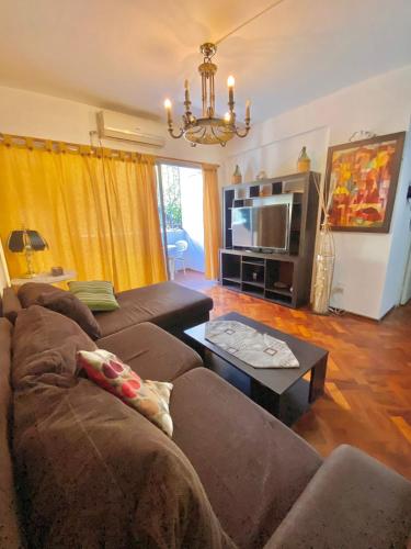 uma sala de estar com um sofá e uma mesa em Departamento Blanca em Mendoza