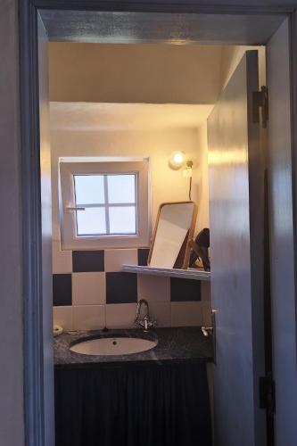 a bathroom with a sink and a window at Monte da Choça in São Teotónio
