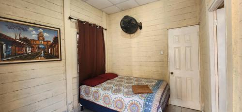 a small bedroom with a bed and a picture on the wall at ECO HOTEL LACHUA in Cobán