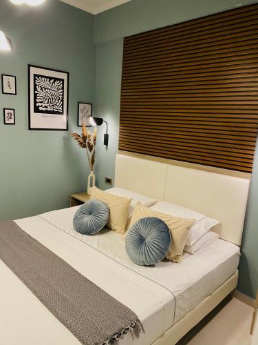 a bedroom with a large bed with blue pillows at Leonidas House in Parga