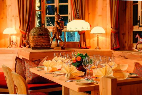 a wooden table with wine glasses and flowers on it at Hotel Grüner Wald in Freudenstadt