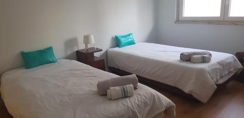two beds sitting next to each other in a room at Sal Guest House in Costa da Caparica