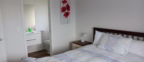ケンブリッジにあるWebber Houseのベッドルーム1室(赤い花の壁にベッド1台付)