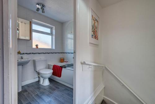 a white bathroom with a toilet and a sink at CAPRI 13 SA - Cosy 2 bed house, Close to M1 & Loughborough University, Free WIFI, Free PARKING, - Ask for contractor rates! in Loughborough