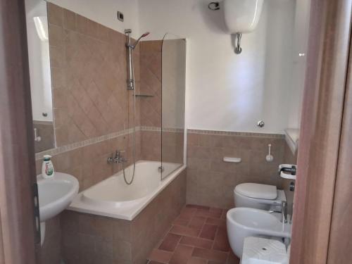 a bathroom with a tub and a sink and a toilet at Guarda che Luna Apartment in Porto Empedocle