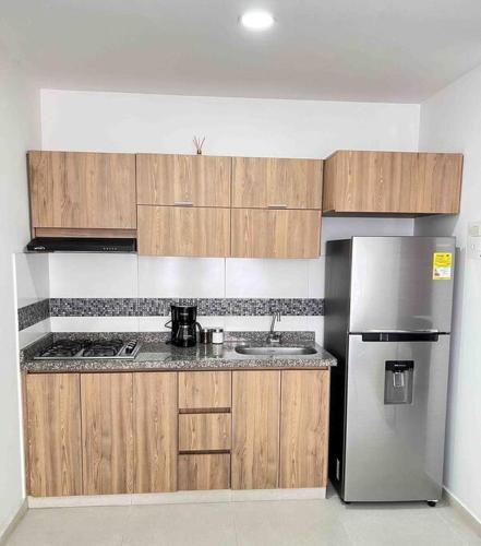 a kitchen with wooden cabinets and a stainless steel refrigerator at 201S Apartamento de ensueño in Vallecito