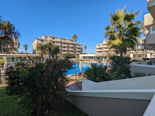 a view of the pool at a resort with palm trees at VilaFplaza by JohnVillas in Portimão