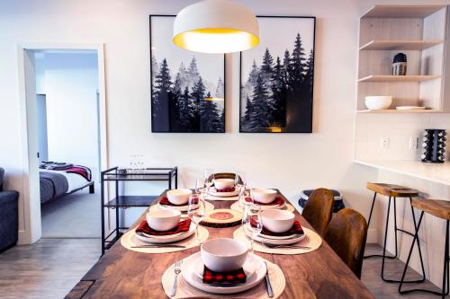 a dining room with a table with dishes on it at Monashee Sunshine - Condo with Private Hot Tub in Revelstoke