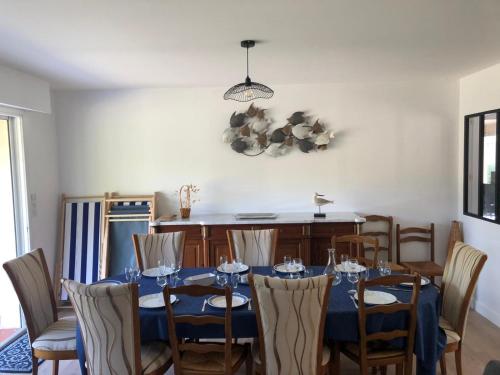 une salle à manger avec une table et des chaises bleues dans l'établissement Agréable maison familiale Proche De l'Océan Grand jardin, à Arthon-en-Retz