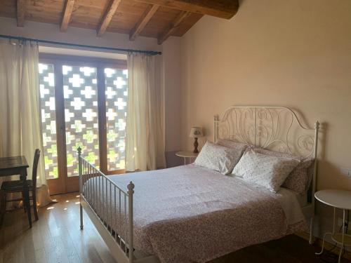 um quarto com uma cama branca e uma grande janela em Agriturismo Il Filare em Neviano degli Arduini