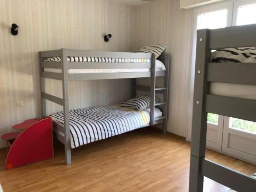 deux lits superposés dans une chambre avec fenêtre dans l'établissement Agréable maison familiale Proche De l'Océan Grand jardin, à Arthon-en-Retz