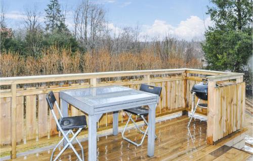 a table and chairs on a deck with a fence at Stunning Home In Ed With Kitchen in Ed