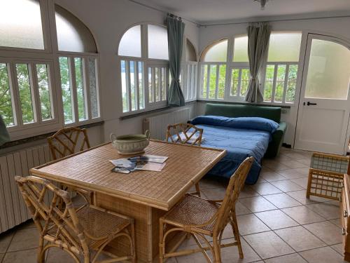 sypialnia ze stołem i łóżkiem z oknami w obiekcie Villa Angela w mieście Dorio