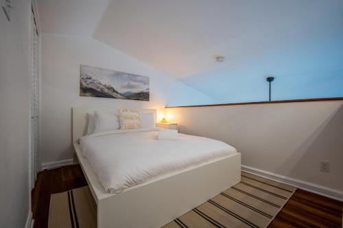 a white bed in a room with a window at Le Colvert by Rendez-Vous Mont-Tremblant in Mont-Tremblant