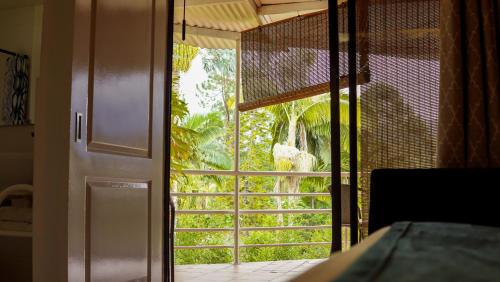 a sliding glass door with a view of a garden at Hotel Campestre Villa Mary in Santa Rosa de Cabal