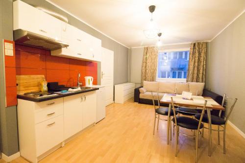 a kitchen and dining room with a table and chairs at Happy Apartments - Economy in Wrocław