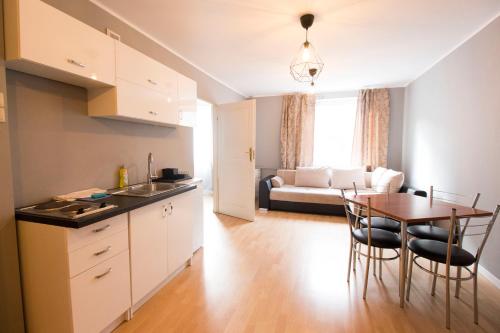 a kitchen and living room with a table and chairs at Happy Apartments - Economy in Wrocław