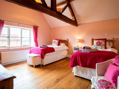 a bedroom with two beds and a window at Rimmers Farmhouse in Wichenford