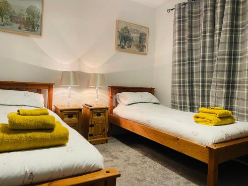 sypialnia z 2 łóżkami i 2 szafkami nocnymi w obiekcie Trawsfynydd Stone Cottage w mieście Trawsfynydd