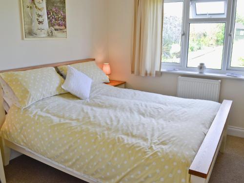 a bedroom with a bed with white sheets and a window at Freshwater Bay View in Southwell