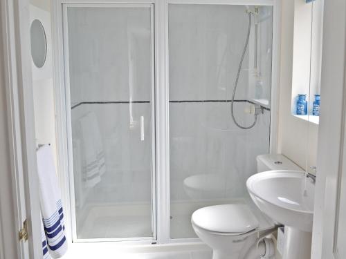 a white bathroom with a shower and a toilet at Freshwater Bay View in Southwell