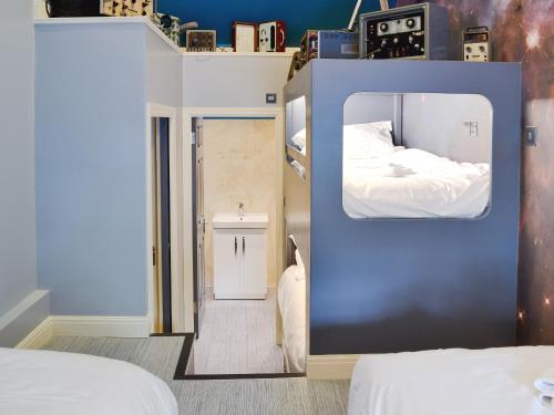 een kleine kamer met een bed en een spiegel bij Moorecroft in Buxton