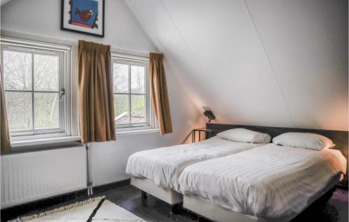 een slaapkamer met een bed en 2 ramen bij Beautiful Home In Hoge Hexel With Kitchen in Hoge-Hexel