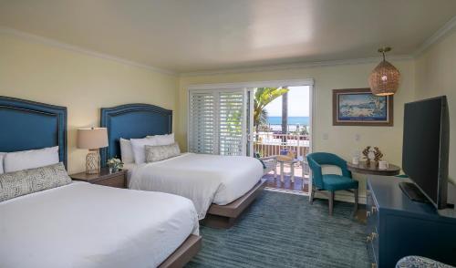 a hotel room with two beds and a balcony at Avila Lighthouse Suites in Avila Beach