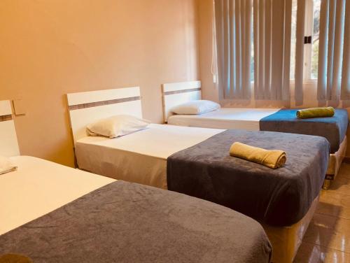 a room with three beds at Turis Hotel in Ciudad del Este