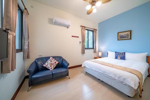 a bedroom with a bed and a chair at Bo Jue Farm Stay in Jian