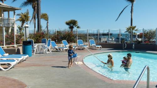 a group of people playing in a swimming pool at Avila Lighthouse Suites in Avila Beach