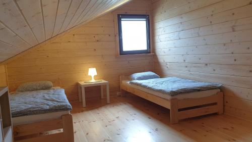 a room with two beds in a log cabin at Domki Masztowa Przystań in Gąski
