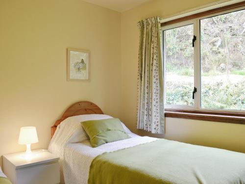 een slaapkamer met een bed en een raam bij Crubisdale in Blairmore