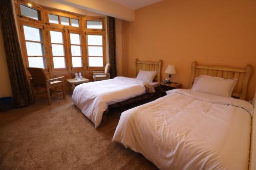a hotel room with two beds and a window at Arcadian 3Skies Gupis in Gupis